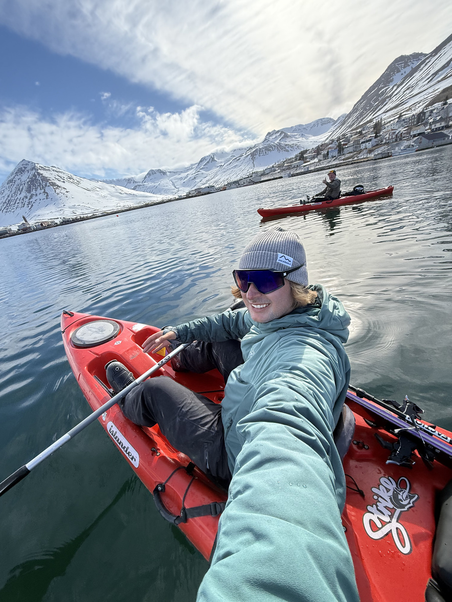 Unterwegs im Kajak auf einem Fjord zwischen schneebedeckten Bergen